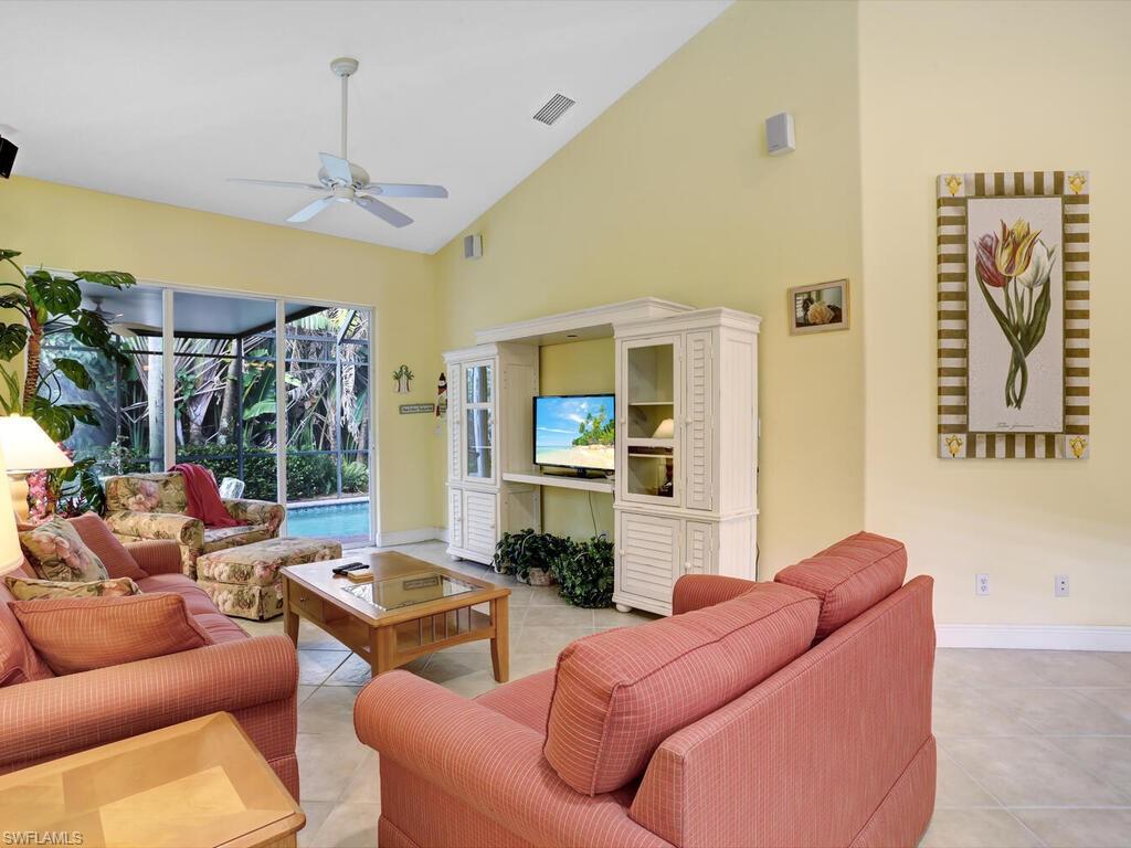 1079 Michigan Avenue Naples, FL 34103 - Photo 12 of 31 a living room with furniture a fireplace and a chandelier
