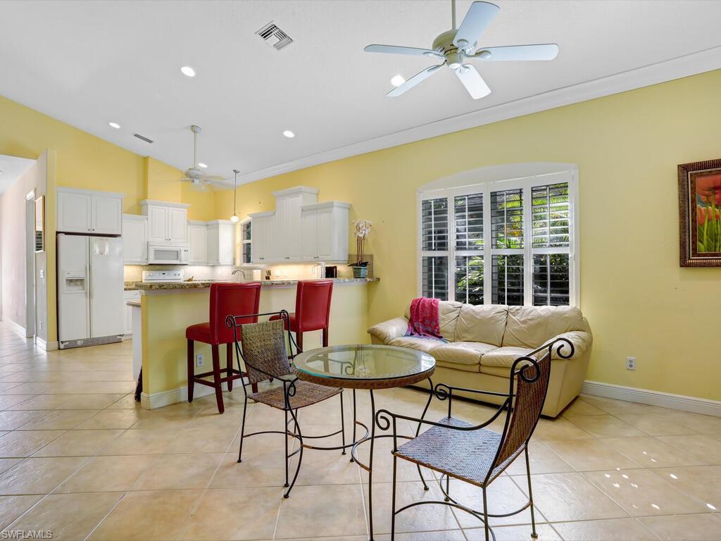 1079 Michigan Avenue Naples, FL 34103 - Photo 15 of 31 a living room with stainless steel appliances kitchen island granite countertop furniture and a chandelier