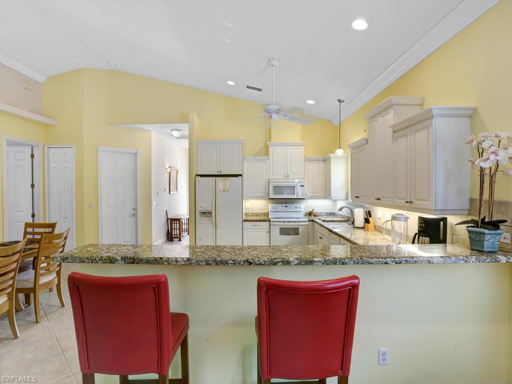 1079 Michigan Avenue Naples, FL 34103 - Photo 17 of 31 a kitchen with stainless steel appliances granite countertop a sink and a refrigerator