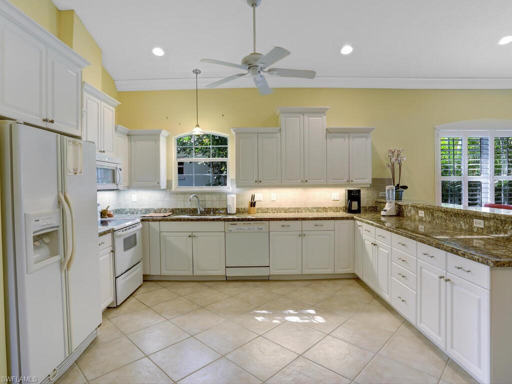 1079 Michigan Avenue Naples, FL 34103 - Photo 19 of 31 a kitchen with stainless steel appliances granite countertop a sink and cabinets