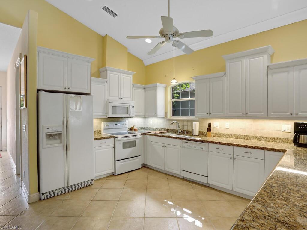 1079 Michigan Avenue Naples, FL 34103 - Photo 20 of 31 a kitchen with stainless steel appliances granite countertop a sink and a refrigerator