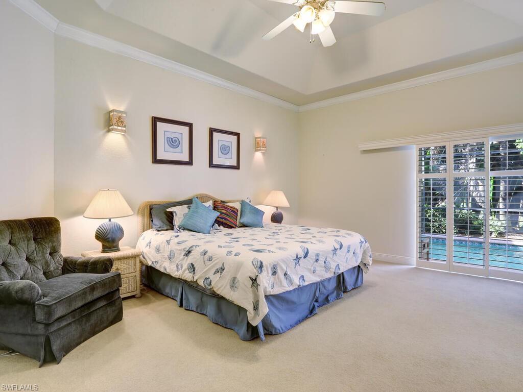 1079 Michigan Avenue Naples, FL 34103 - Photo 22 of 31 a spacious bedroom with a bed couch chandelier and a window