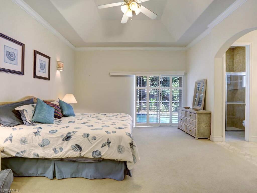 1079 Michigan Avenue Naples, FL 34103 - Photo 23 of 31 a bedroom with a large bed and a chandelier