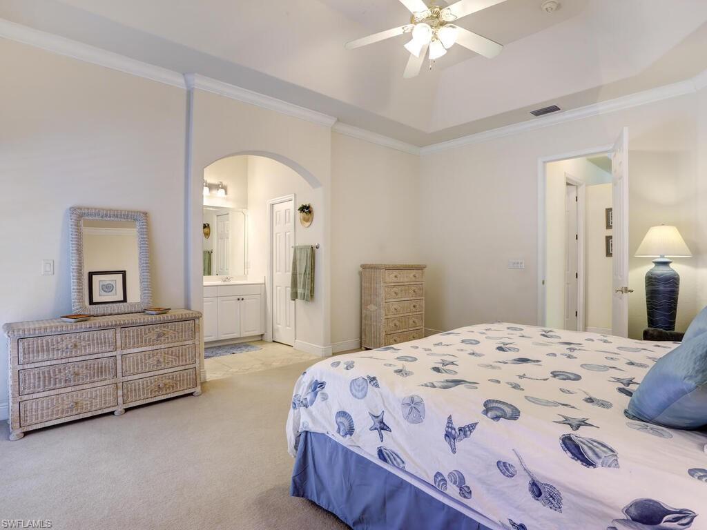 1079 Michigan Avenue Naples, FL 34103 - Photo 24 of 31 a spacious bedroom with a bed and a chandelier