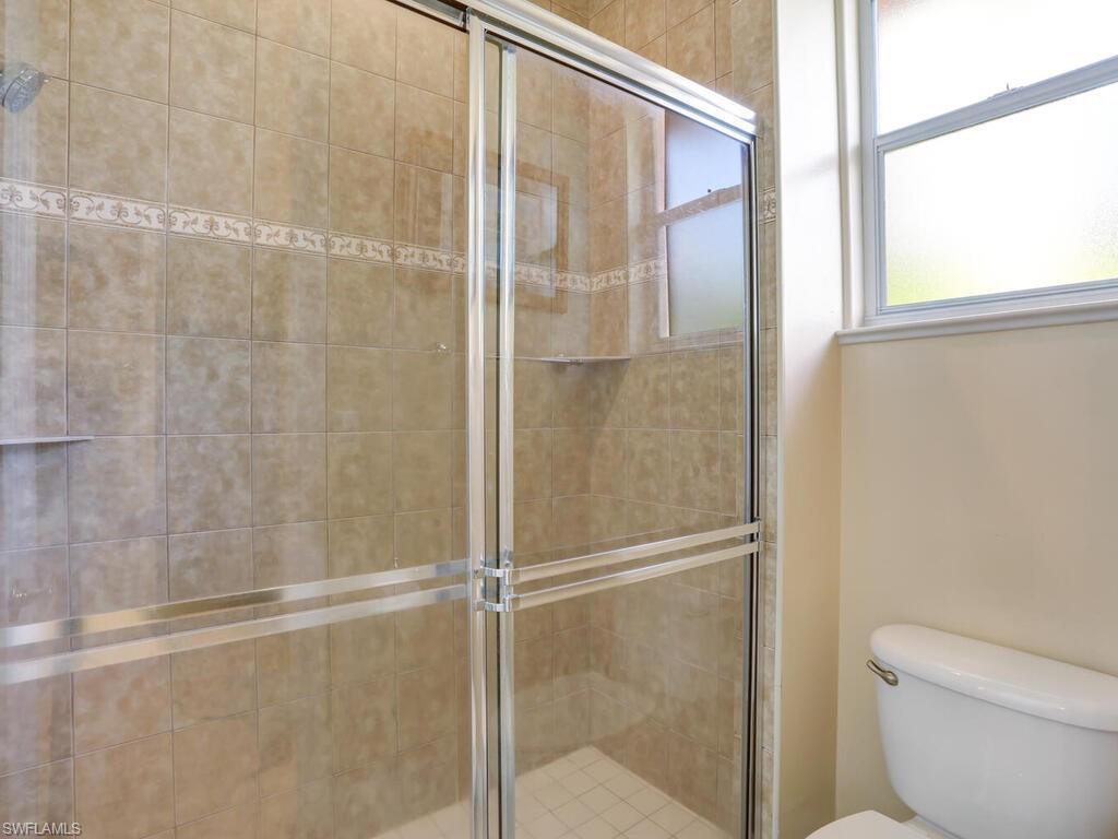 1079 Michigan Avenue Naples, FL 34103 - Photo 26 of 31 a bathroom with a glass shower door
