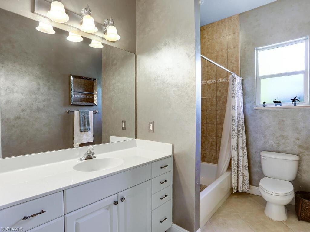 1079 Michigan Avenue Naples, FL 34103 - Photo 29 of 31 a bathroom with a toilet a sink and a mirror