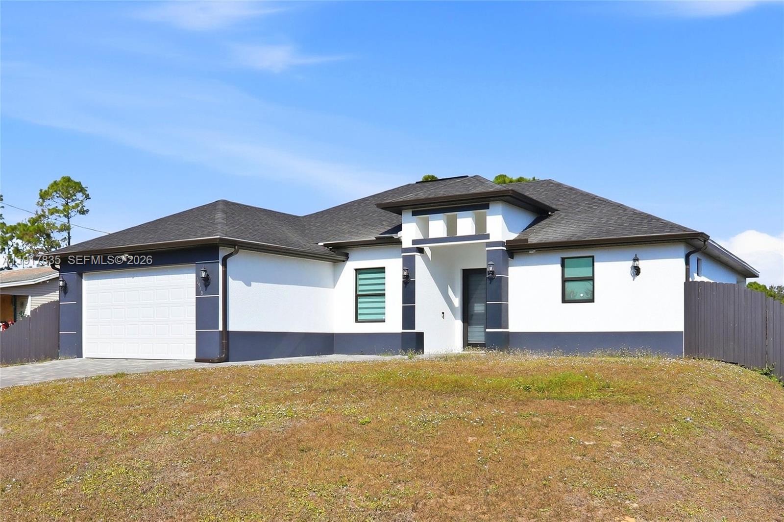 2908 9th Street Southwest Lehigh Acres, FL 33976 - Photo 2 of 44 a front view of a house with a yard and garage