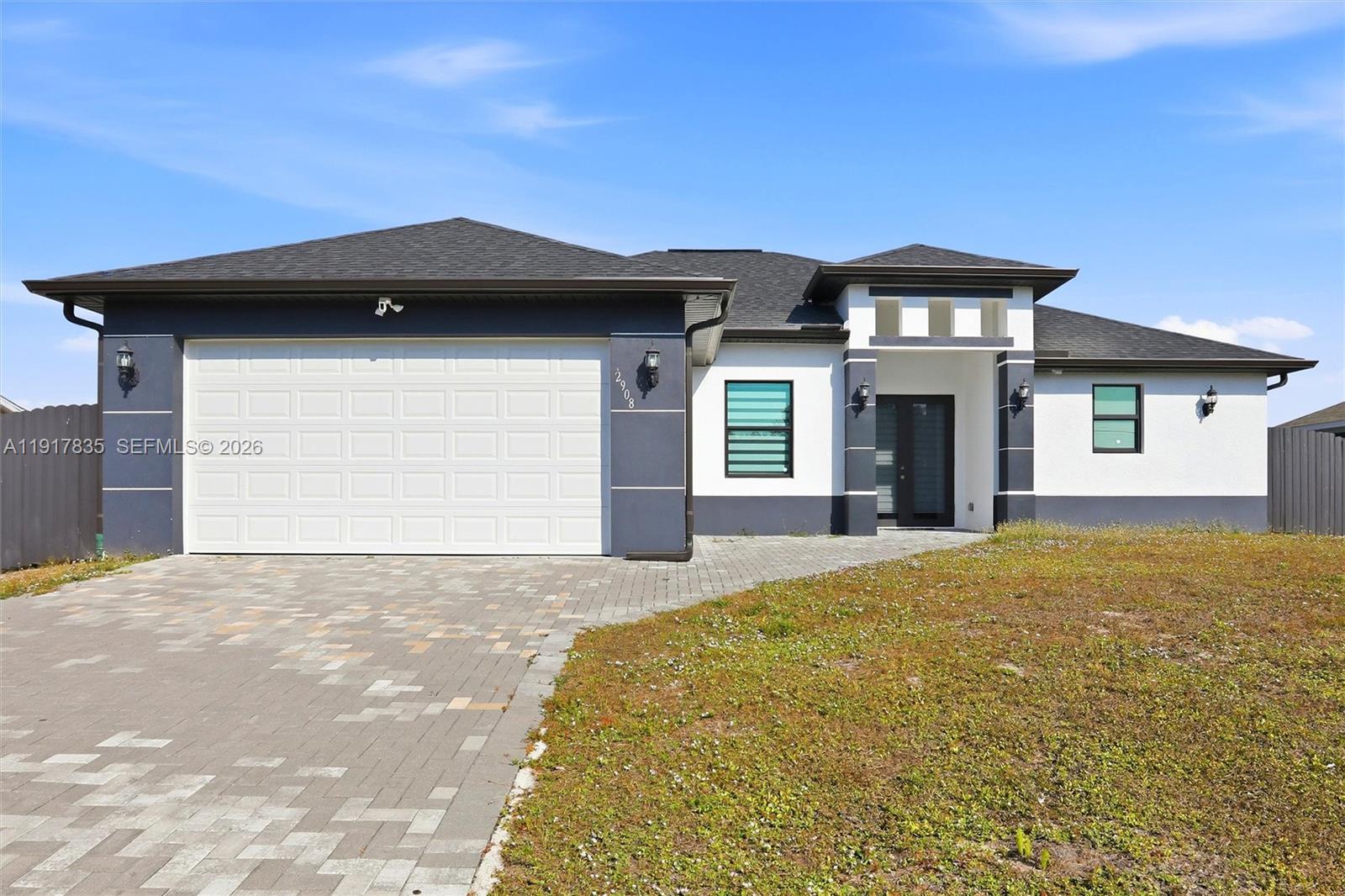 2908 9th Street Southwest Lehigh Acres, FL 33976 - Photo 3 of 44 a front view of a house with a yard and garage