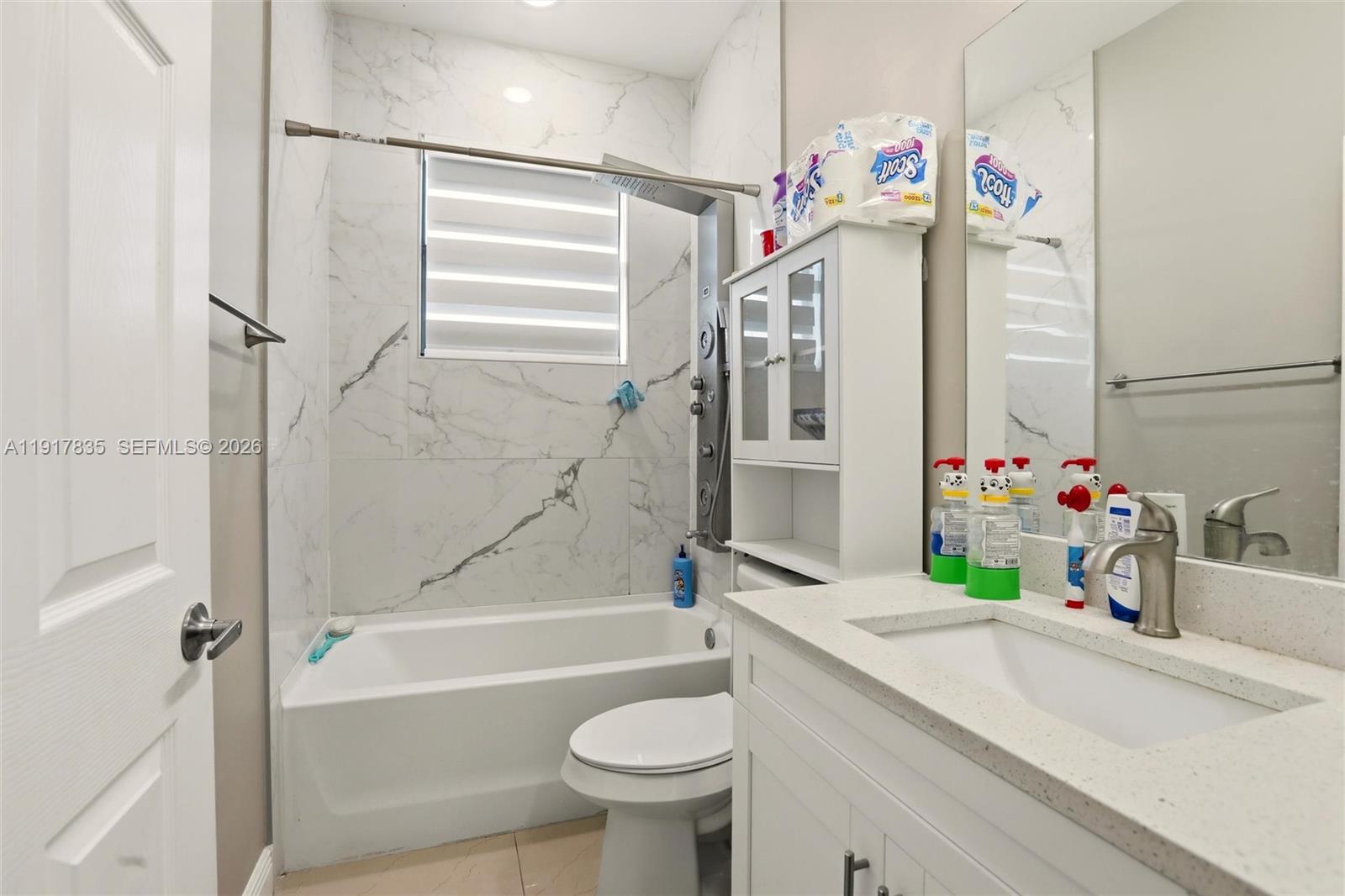 2908 9th Street Southwest Lehigh Acres, FL 33976 - Photo 34 of 44 a bathroom with a sink vanity mirror bathtub and toilet