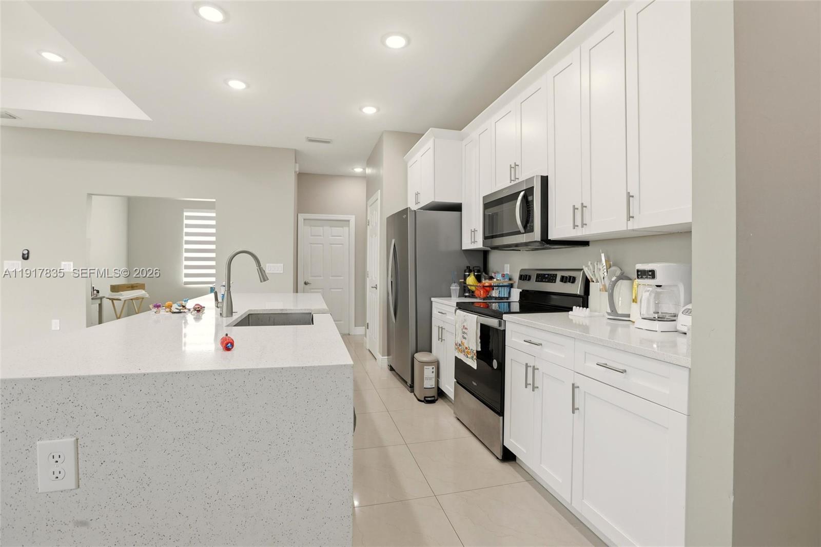 2908 9th Street Southwest Lehigh Acres, FL 33976 - Photo 9 of 44 a kitchen with kitchen island a sink stainless steel appliances and cabinets