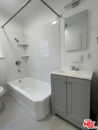 a bathroom with a tub sink and a mirror