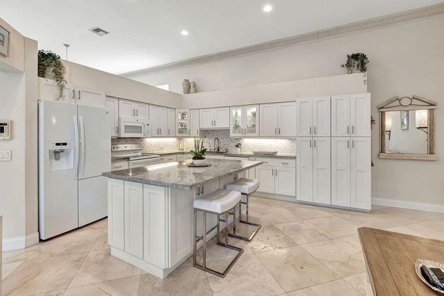 a kitchen with kitchen island a sink cabinets and stainless steel appliances