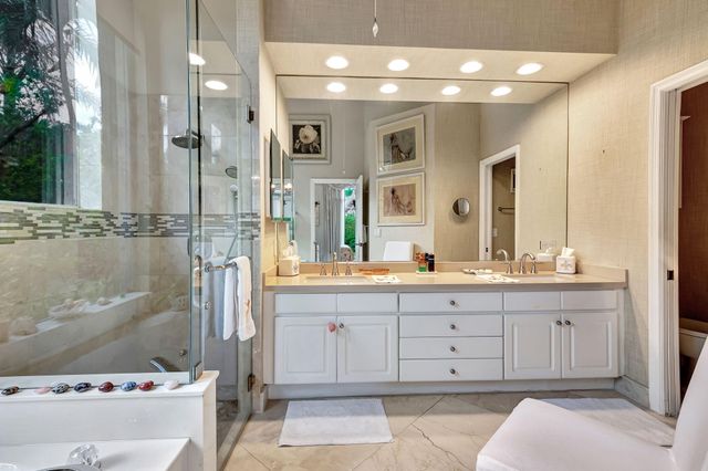 a bathroom with a granite countertop sink a mirror and a bathtub
