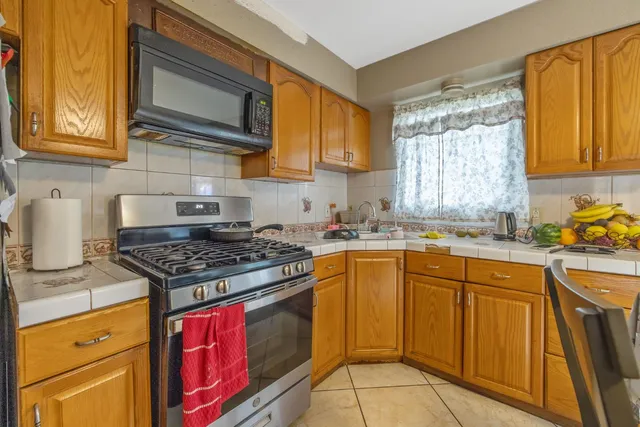 a kitchen with granite countertop a stove top oven microwave and cabinets