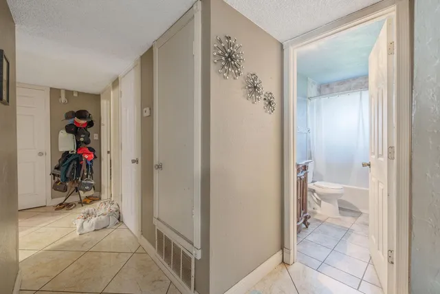 a view of a hallway with closet and a livingroom view