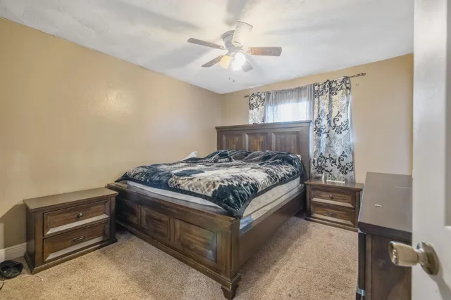 a bedroom with a bed and a ceiling fan