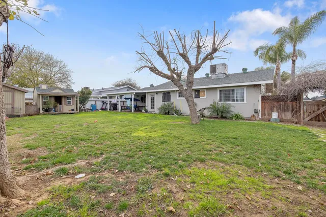 a view of a house with a big yard and potted plants