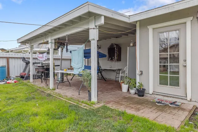 a view of a chair and table in backyard of the house