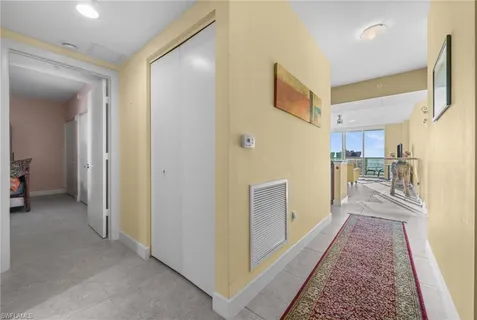 a view of hallway with furniture and a refrigerator