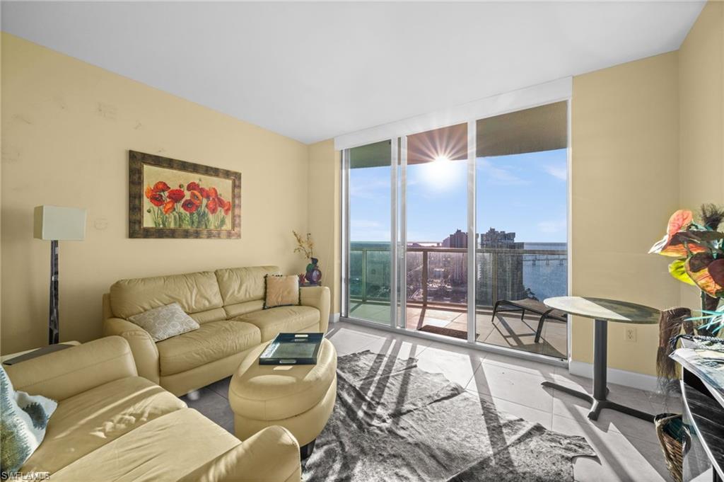 3000 Oasis Grand Boulevard, Unit 2702 Fort Myers, FL 33916 - Photo 18 of 34 a living room with furniture and a floor to ceiling window