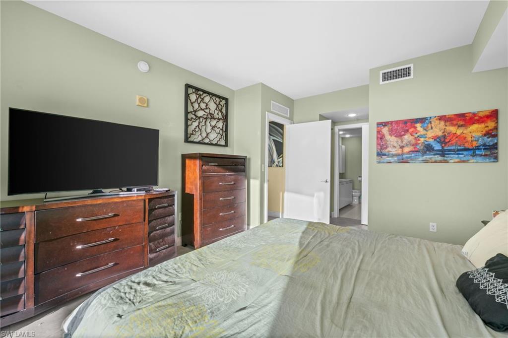 3000 Oasis Grand Boulevard, Unit 2702 Fort Myers, FL 33916 - Photo 23 of 34 a bedroom with a bed and a flat screen tv