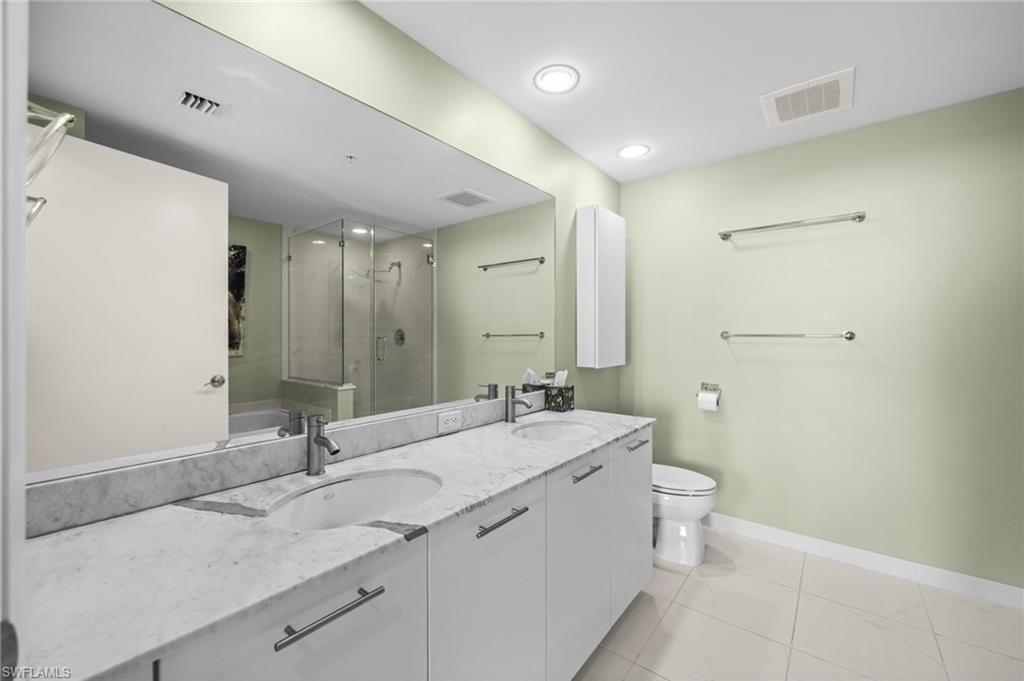 3000 Oasis Grand Boulevard, Unit 2702 Fort Myers, FL 33916 - Photo 25 of 34 a bathroom with a granite countertop sink a toilet and a mirror