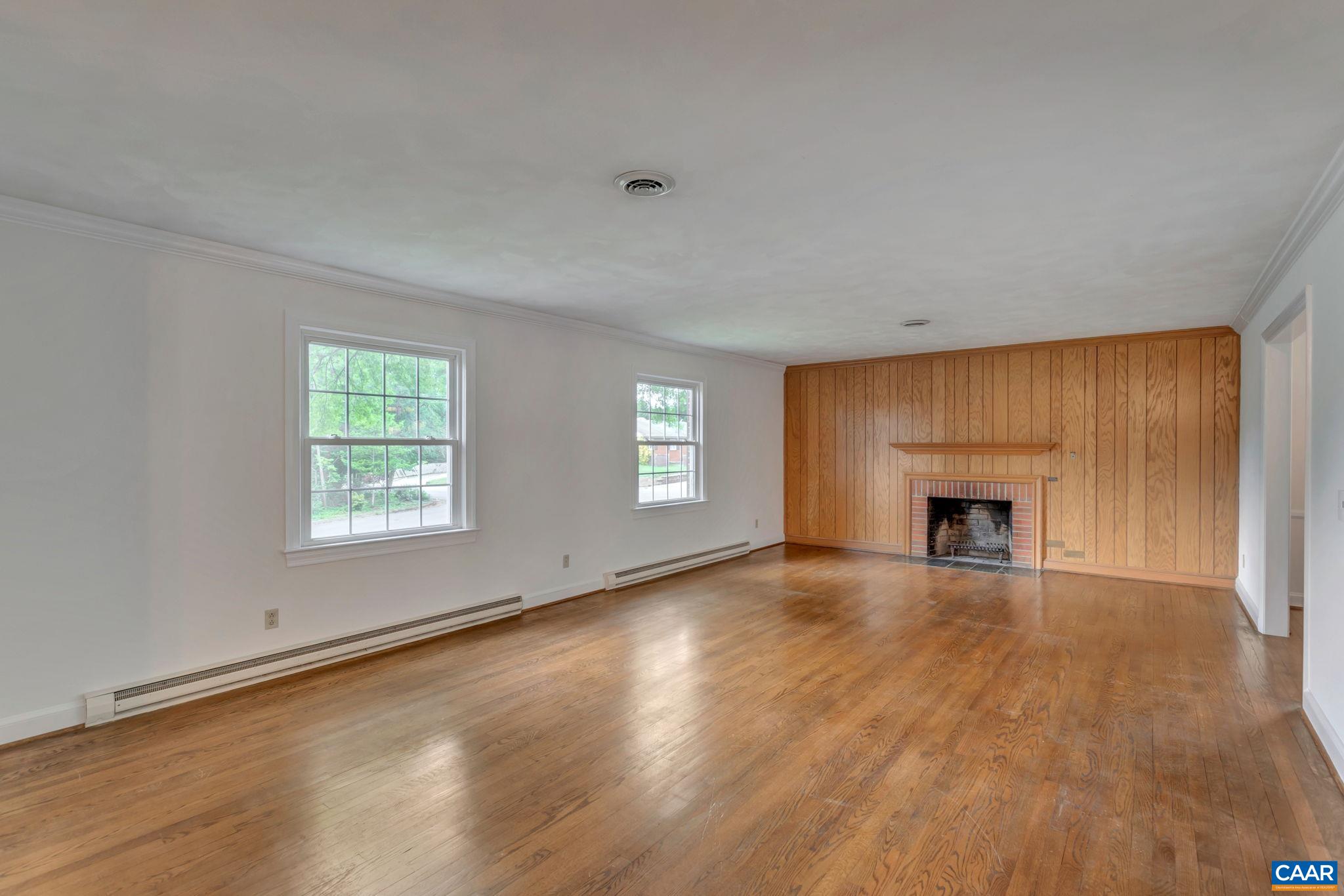 2602 Bennington Road Charlottesville, VA 22901 - Photo 8 of 50 an empty room with windows fireplace and wooden floor