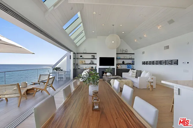 a living room with furniture kitchen view and a large window