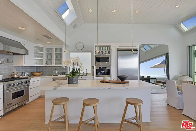 a kitchen with stainless steel appliances kitchen island granite countertop a stove a sink and a refrigerator