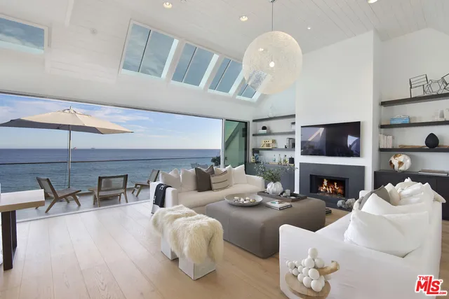 a living room with furniture a flat screen tv and kitchen view