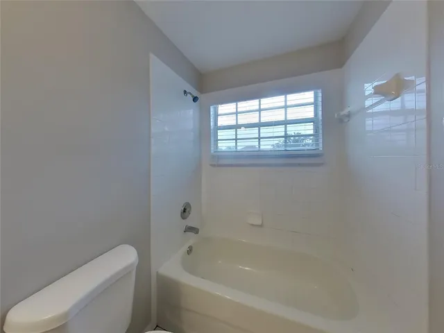 a white bath tub sitting next to a toilet