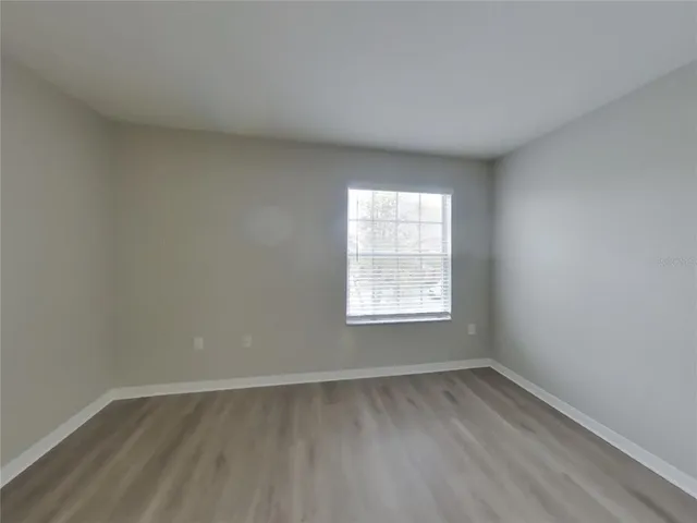 an empty room with wooden floor and window