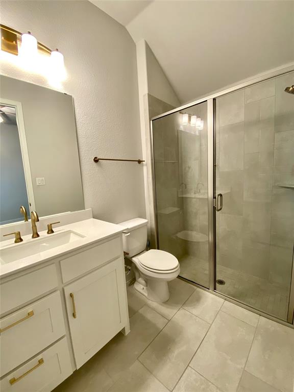 1937 Halkin Road Celina, TX 75009 - Photo 7 of 20 Bathroom with a glass-enclosed shower, white vanity with gold-tone hardware, white countertop, and light tile flooring