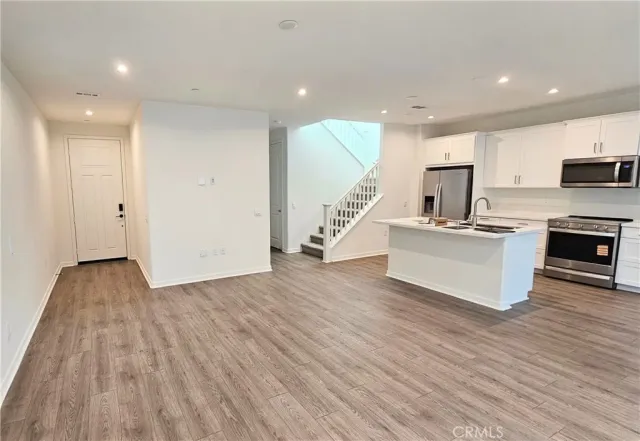 a view of kitchen with sink and refrigerator