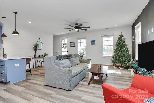 a living room with furniture a chandelier and a flat screen tv