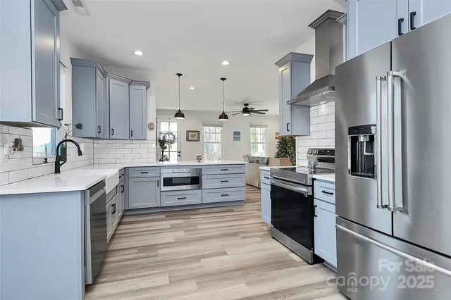 a kitchen with stainless steel appliances granite countertop a refrigerator stove and sink