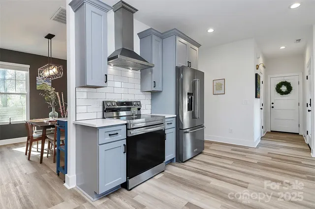 a kitchen with stainless steel appliances granite countertop a refrigerator and a stove top oven