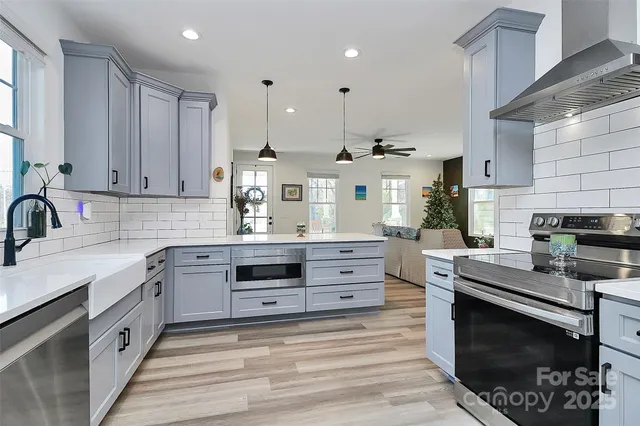 a kitchen with stainless steel appliances granite countertop a stove a sink and a microwave