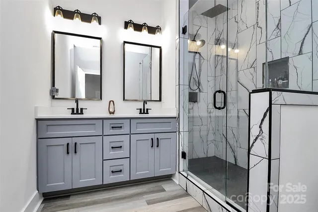 a bathroom with a granite countertop sink a mirror a vanity and a shower