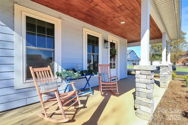 a view of a patio with a dining table and chairs with wooden floor