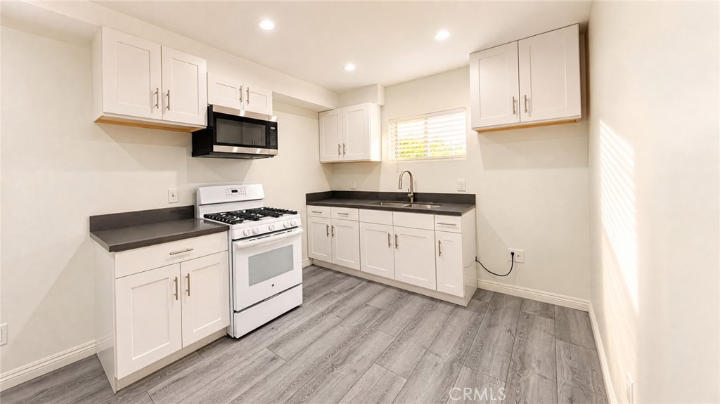 6851 Foothill Boulevard Tujunga, CA 91042 - Photo 4 of 50 a kitchen with white cabinets stainless steel appliances and sink