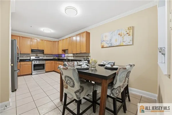 a kitchen with stainless steel appliances a table and chairs in it