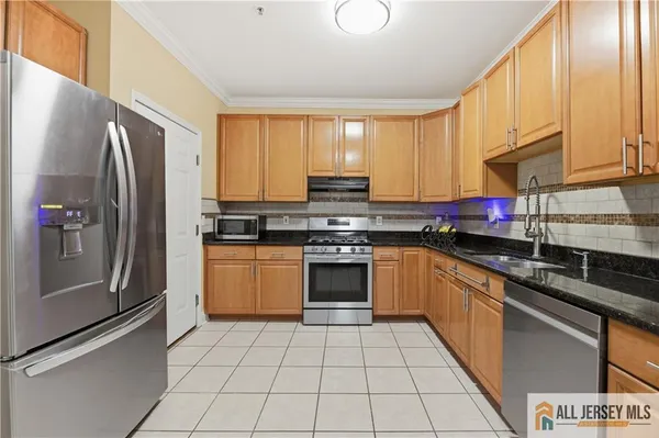 a kitchen with stainless steel appliances granite countertop a stove a sink and a refrigerator