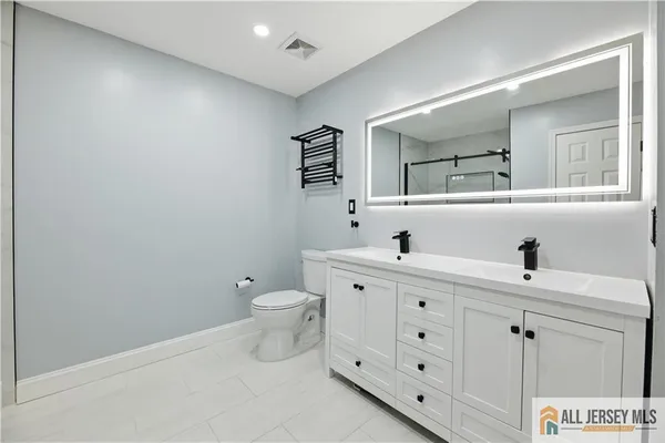 a bathroom with a toilet sink and mirror