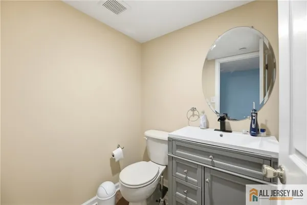 a bathroom with a sink vanity mirror and toilet