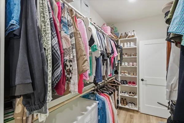 a view of walk in closet with clothes