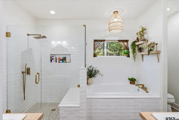 a bathroom with a tub sink and glass door shower