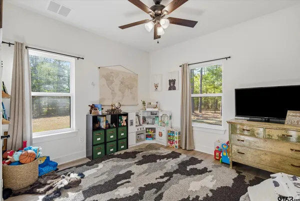 a bedroom with furniture and a flat screen tv