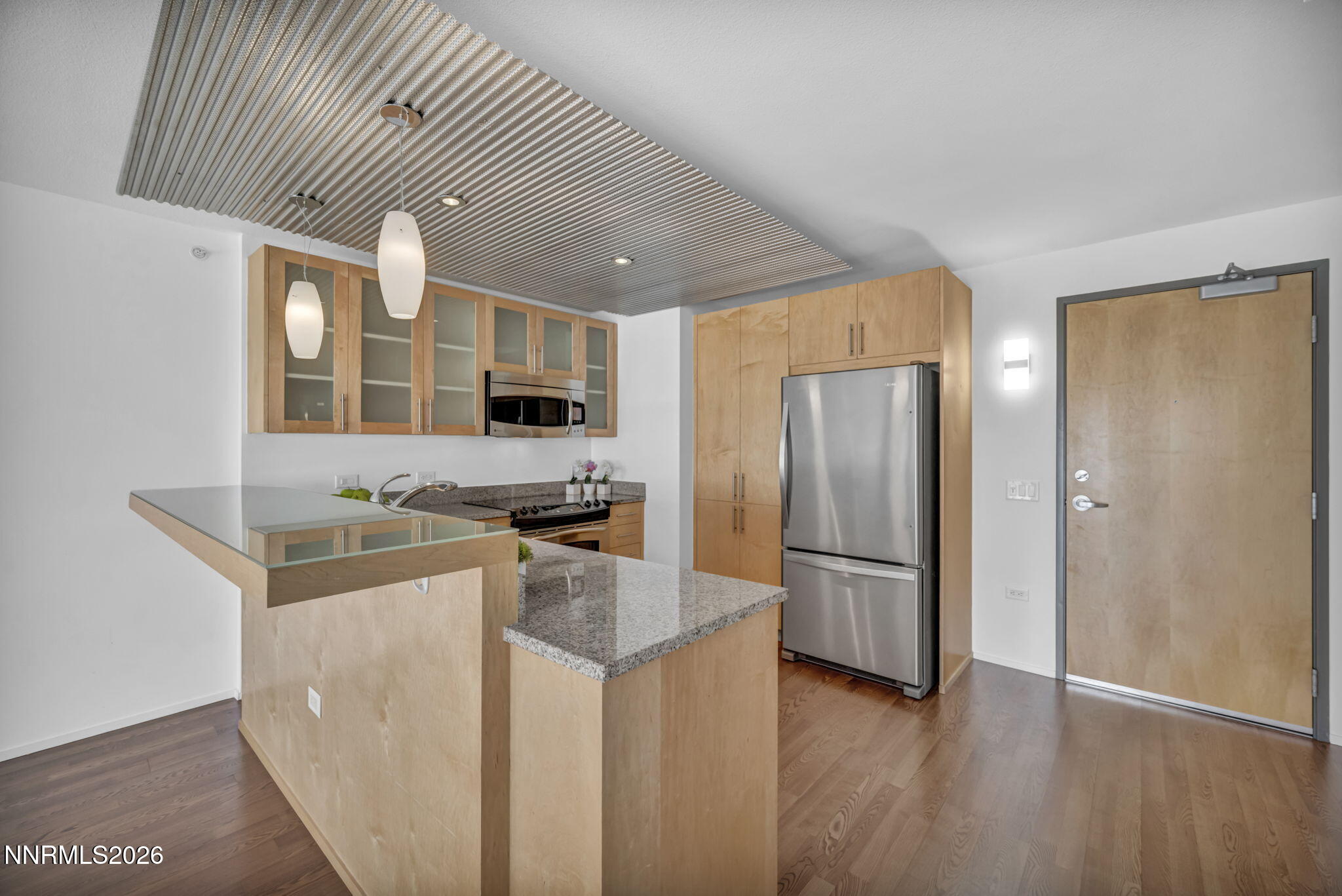 255 North Sierra Street, Unit 1208 Reno, NV 89501 - Photo 10 of 37 a kitchen with stainless steel appliances granite countertop a refrigerator a sink dishwasher a stove and a dining table with wooden floor