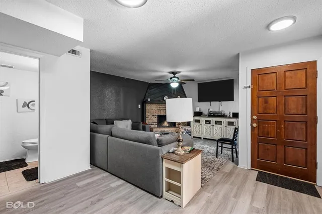 a living room with furniture a fireplace and a flat screen tv